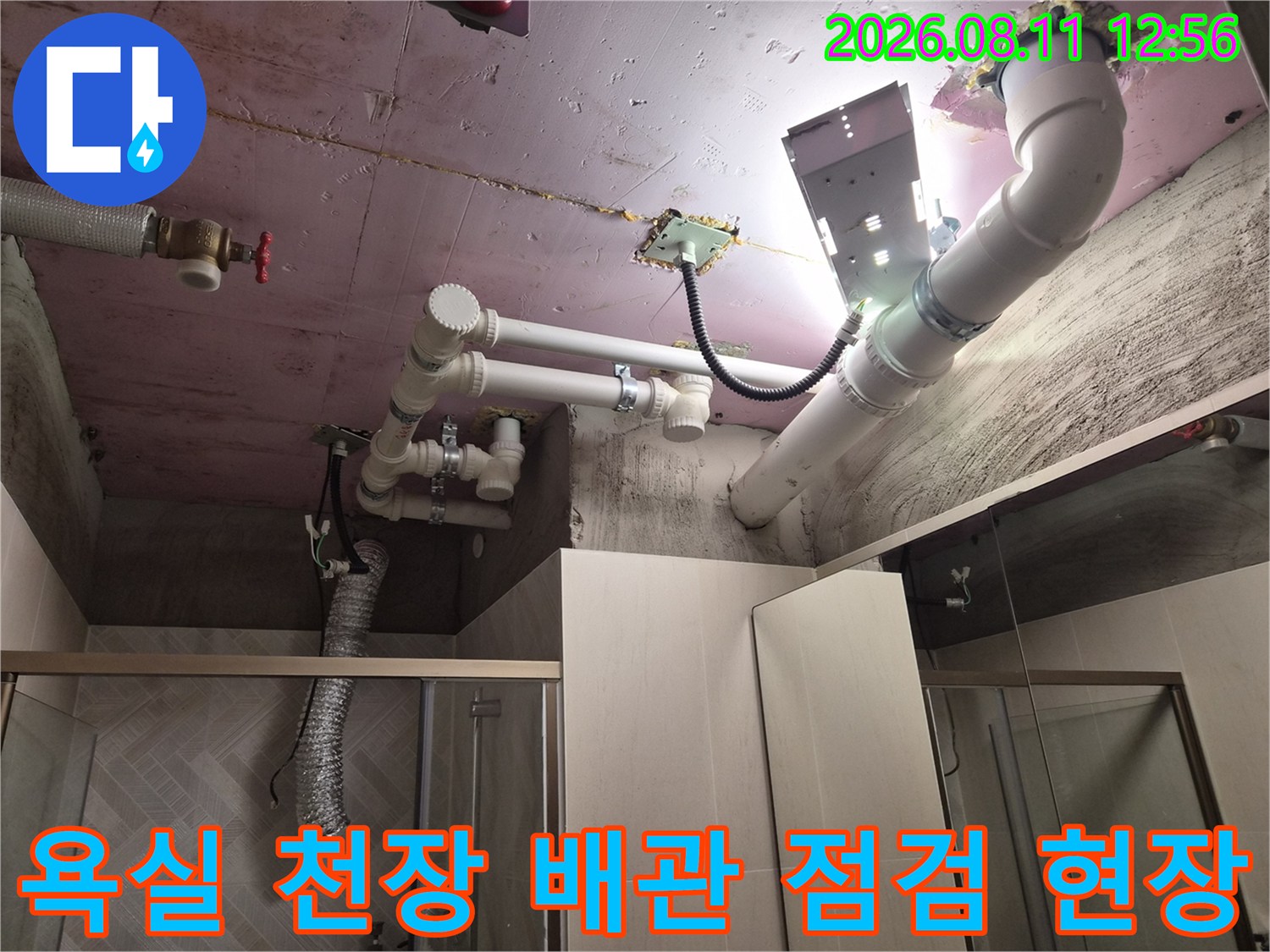 조명을 사용하여 확인 중인 욕실 천장 내부의 PVC 배관 구조
