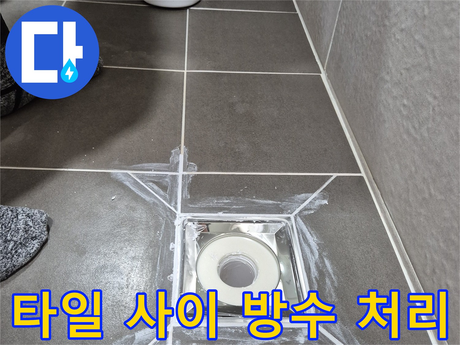 화장실 타일-배수구 주변에 흰색 실란트를 넓게 도포한 모습