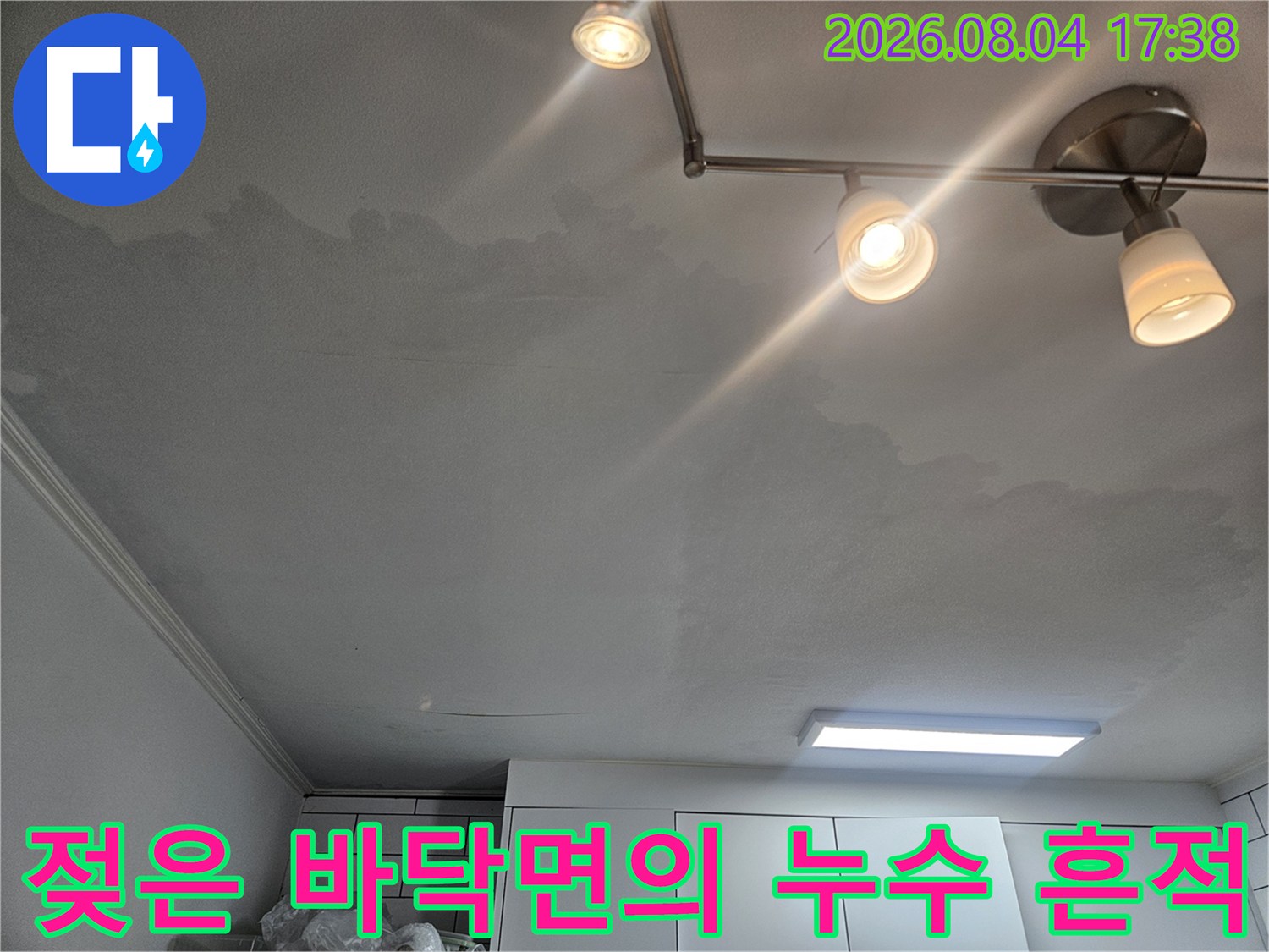 바닥재 위로 번진 물자국과 탐지 장비가 배치된 장면