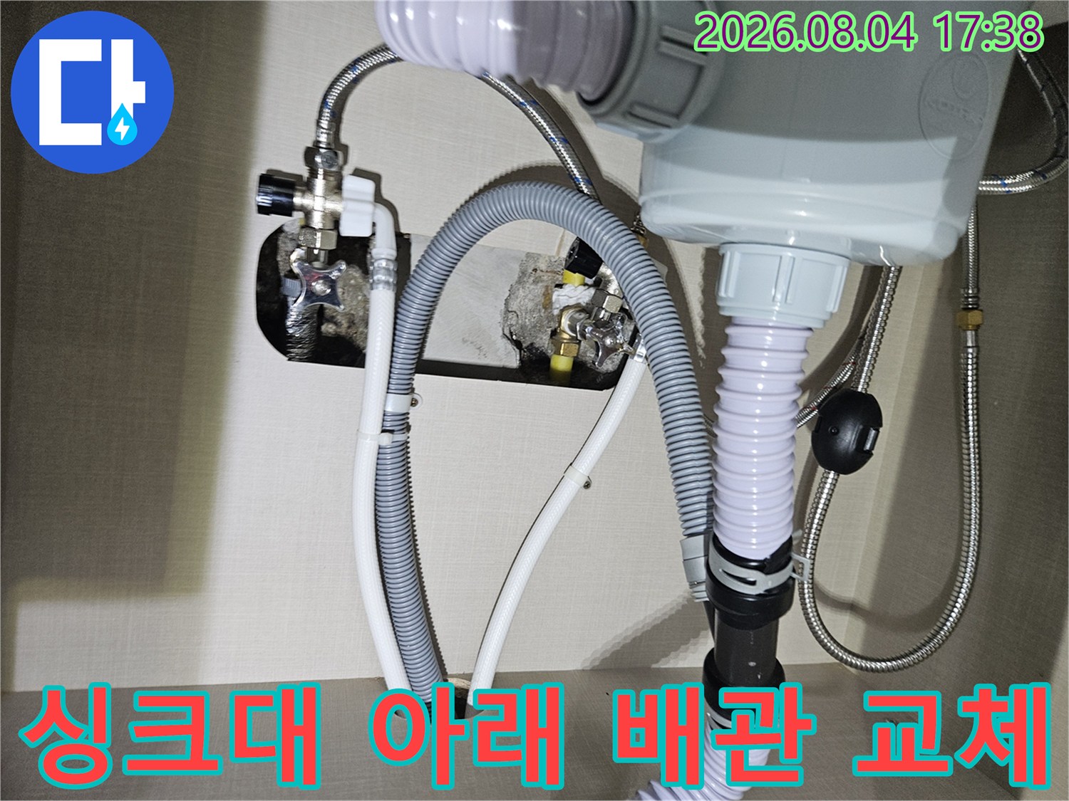 싱크대 밑바닥에 노출된 온수 및 냉수용 트윈 호스와 연결부 자재를 수리하는 모습