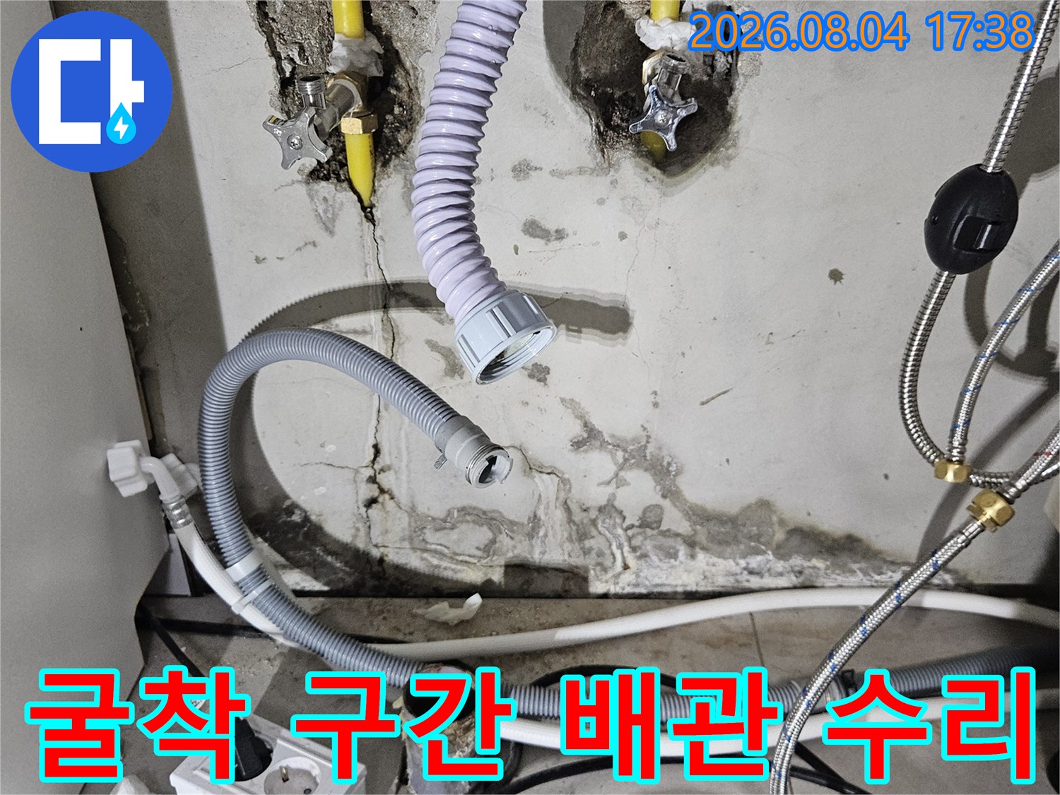 싱크대 하부 벽면을 뚫어 노란색 온수 파이프를 보수한 시공 모습