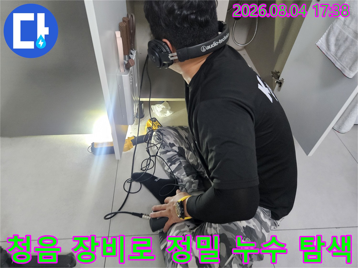 헤드셋과 청음 장비를 사용하여 매립 배관의 이상 부위를 찾는 모습