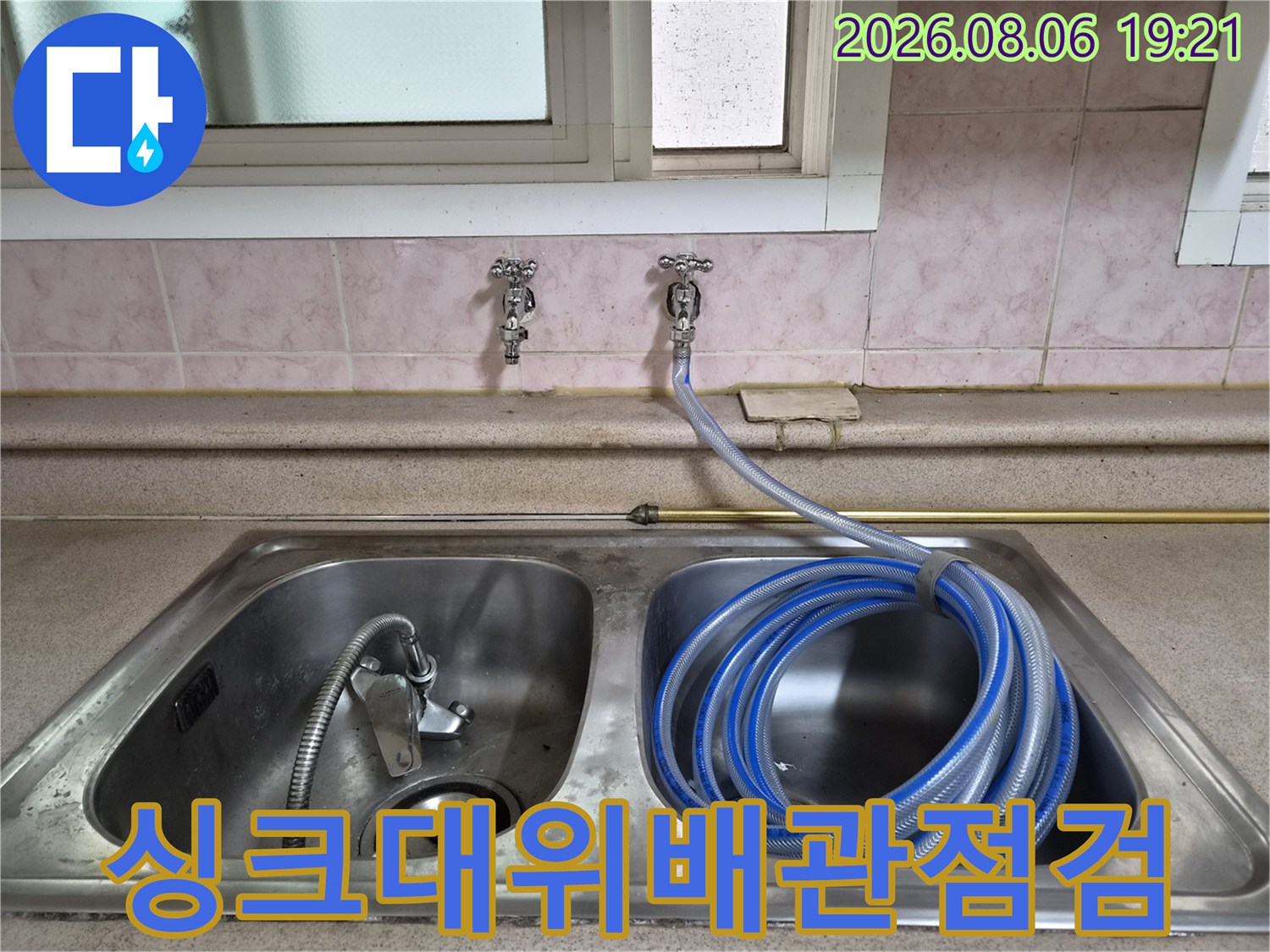 파란색 압력측정 호스가 연결된 싱크대 위쪽 배관 점검 장면