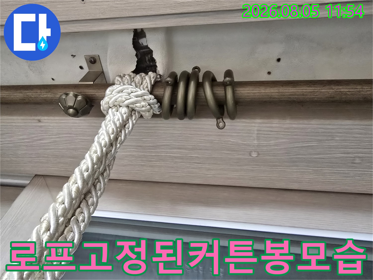 창가에 설치된 커튼 봉과 작업용 로프가 묶여 있는 모습
