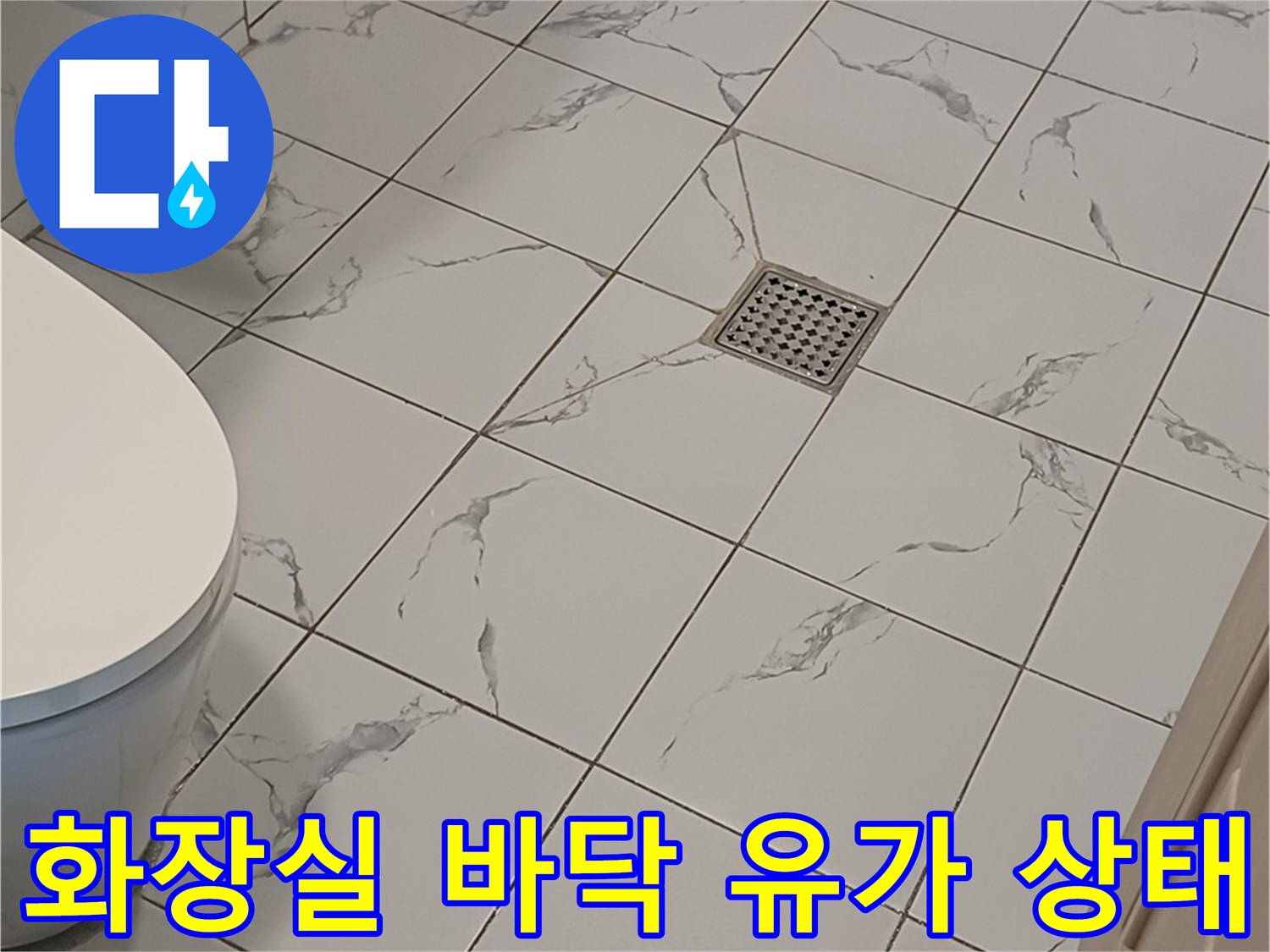 욕실 바닥의 배수구와 주변 타일 마감 상태 사진