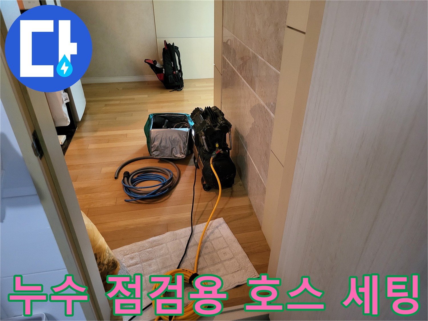 나무 바닥 위에 배치된 누수 탐지용 압력계와 연결 호스들
