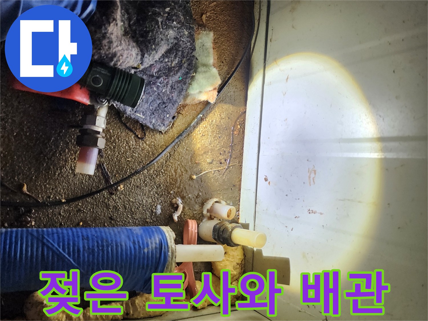 누수 지점 주변의 젖은 흙과 노출된 배관 부품을 촬영한 사진-현장 점검