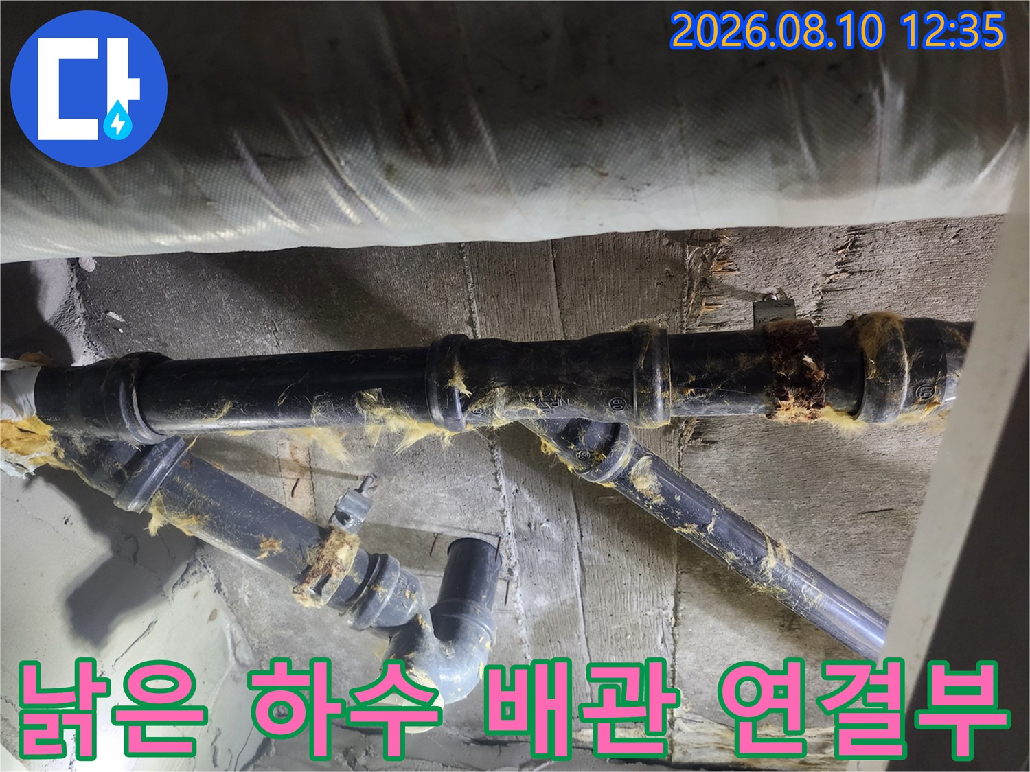 누수가 발생한 지점으로 보이는 낡은 검은색 배관의 연결 부위 상세 사진입니다.