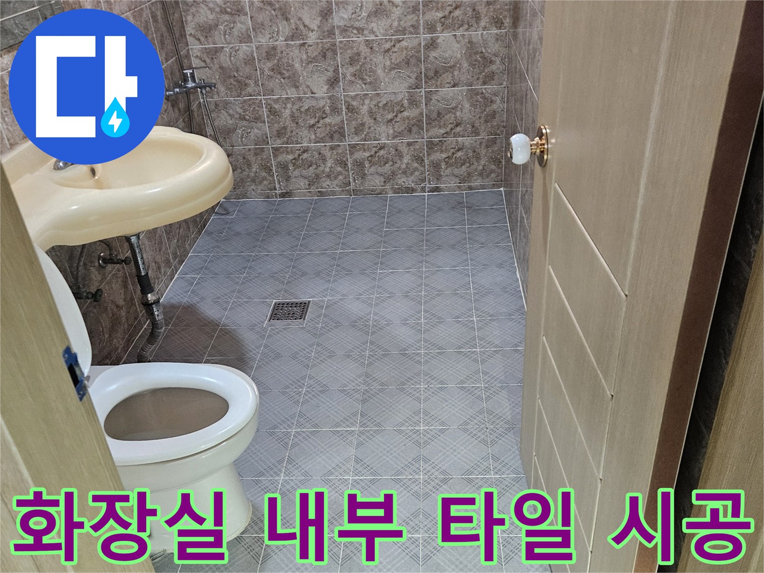 변기와 세면대가 설치된 욕실의 타일 마감 상태입니다.