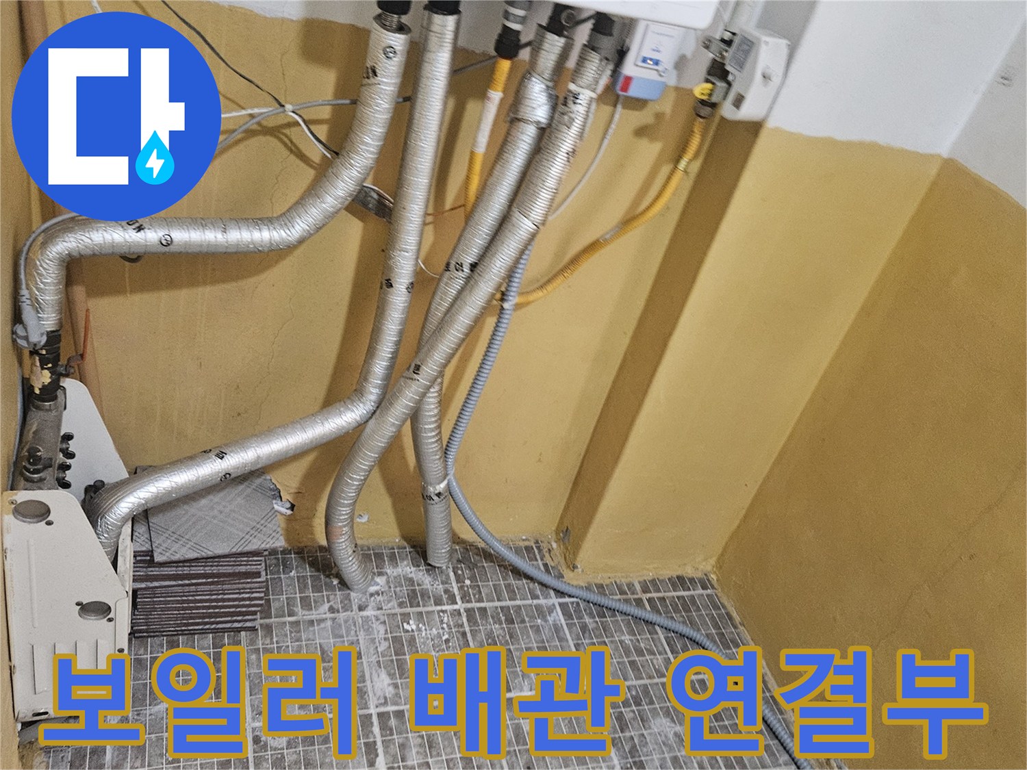 보일러 하단에 연결된 은색 보온재 배관 모습입니다.