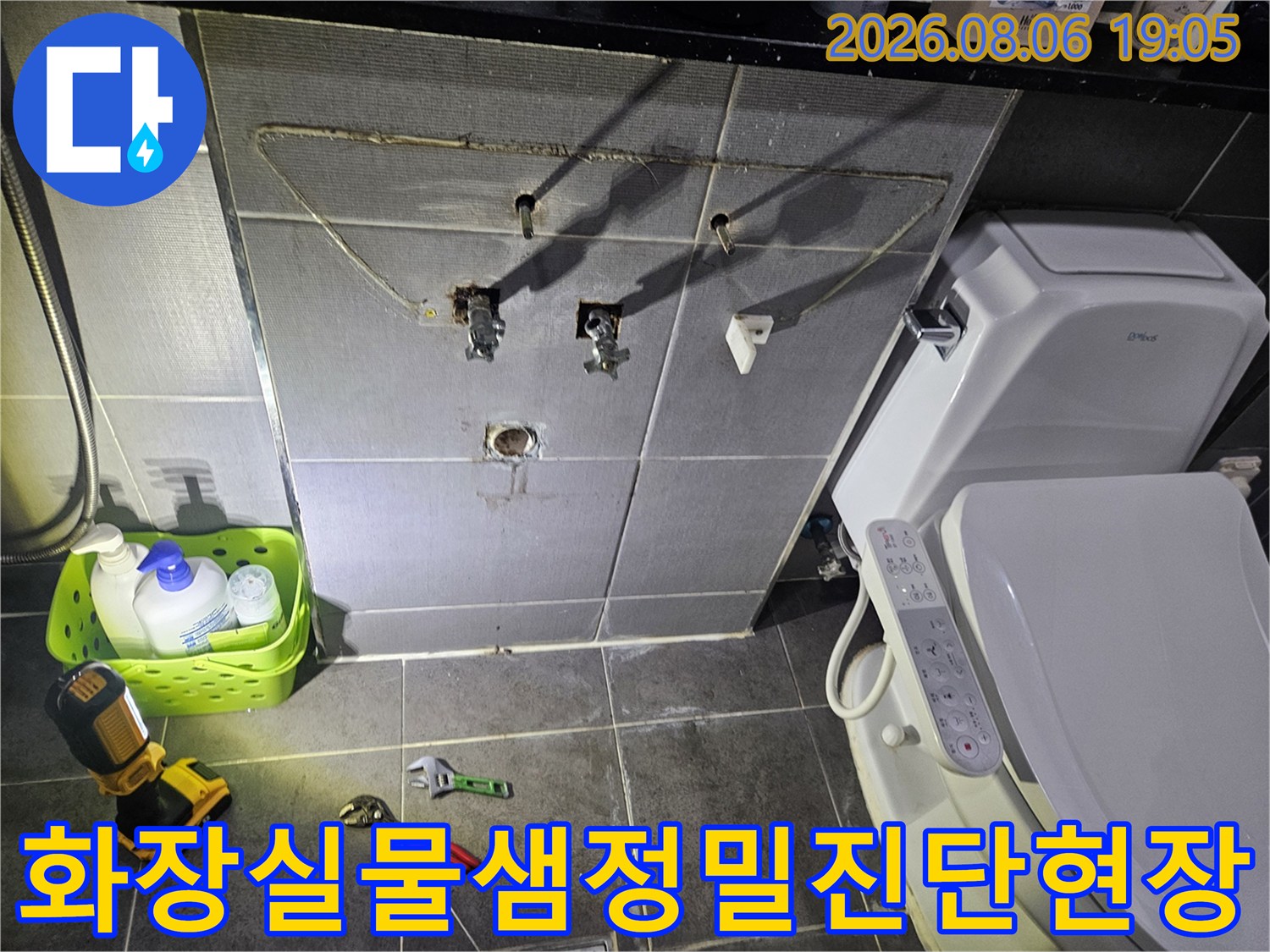 측정 장비와 수리 공구가 배치된 화장실 배관 점검 구역