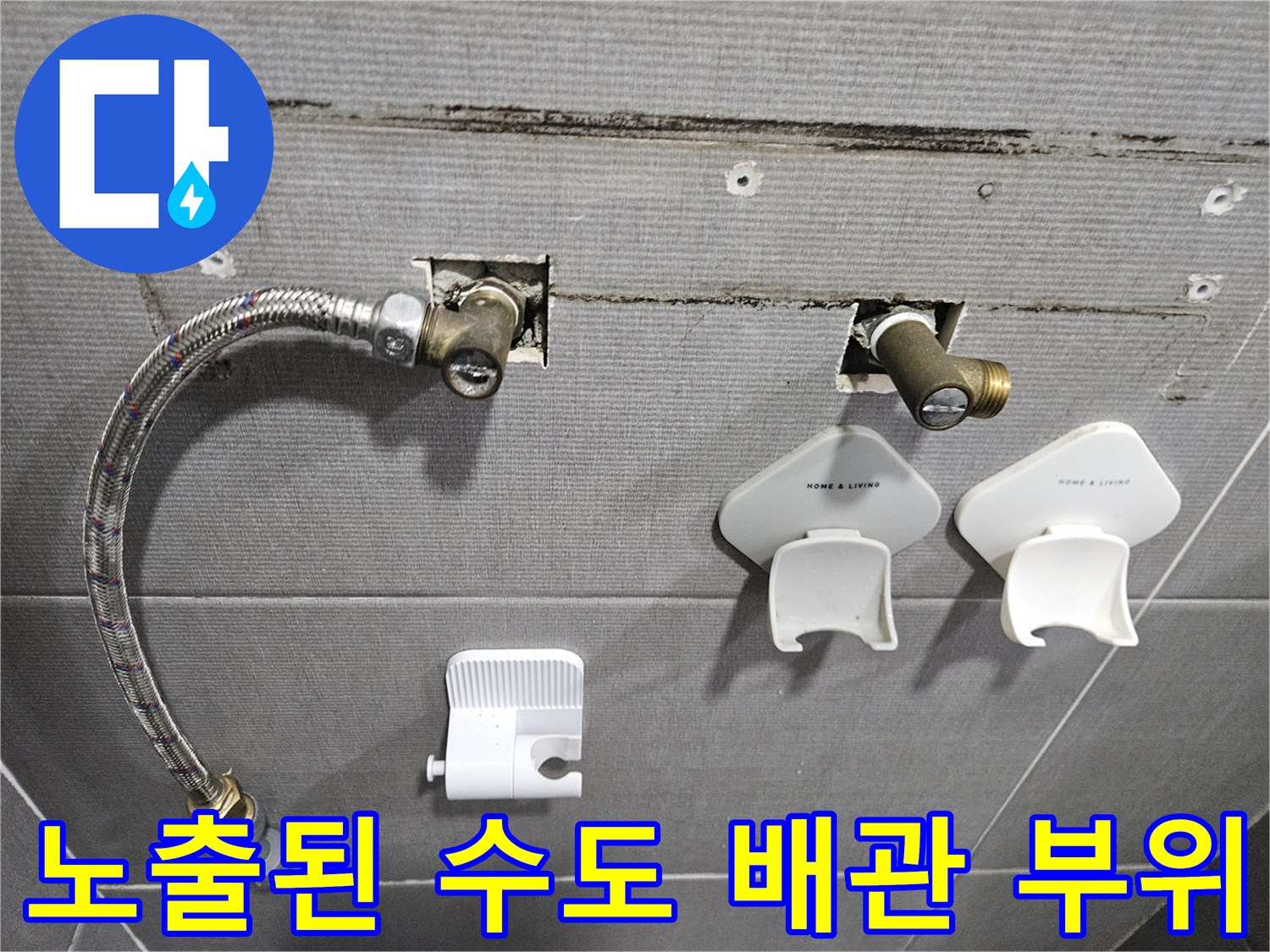 화장실 벽체 내부-드러난 수도 연결 부속과 호스