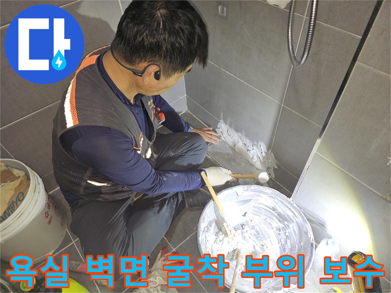 화장실 타일 아래 배관 주변을 미장하는 작업 장면