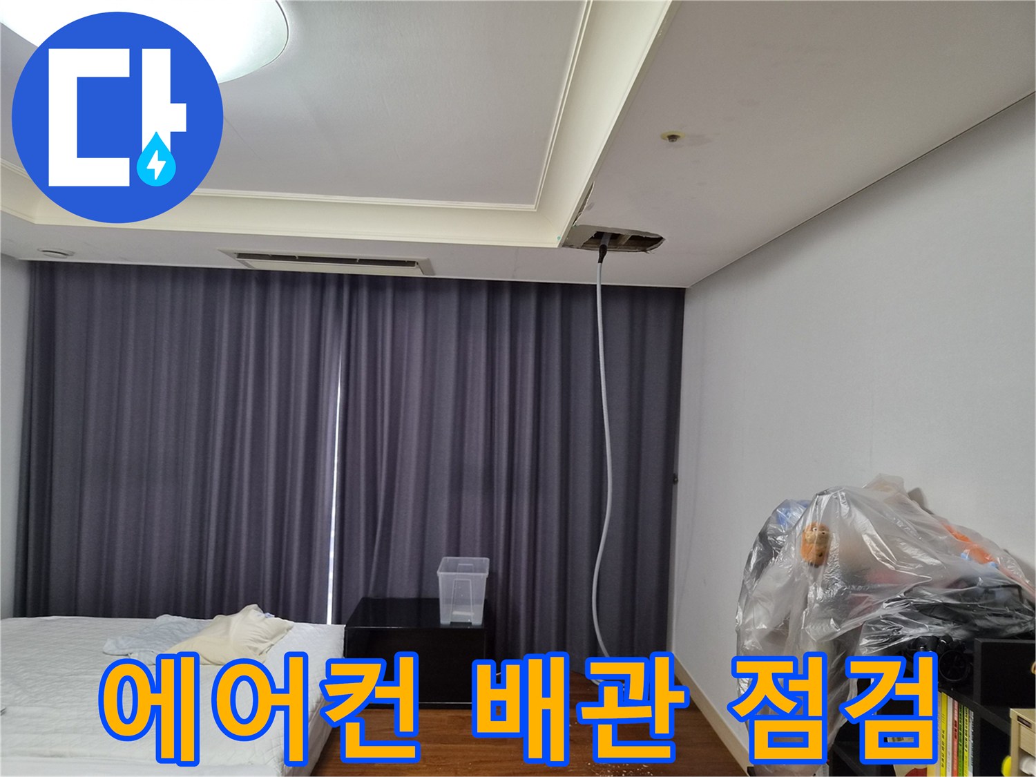 에어컨 천장 점검구 근처의 배수 배관 상태를 확인하는 모습