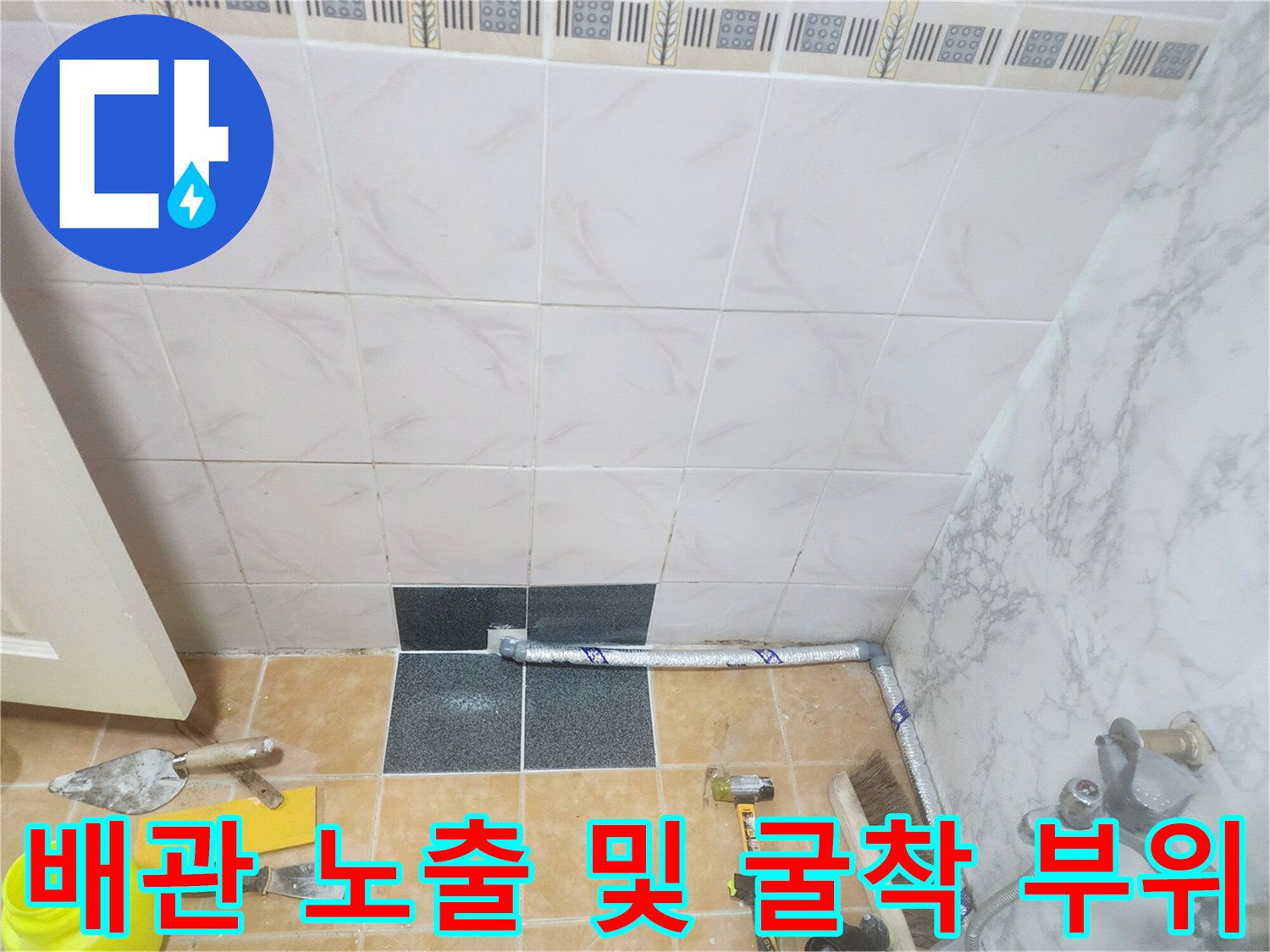 타일 제거 후 드러난 바닥 배관과 작업용 미장 도구들