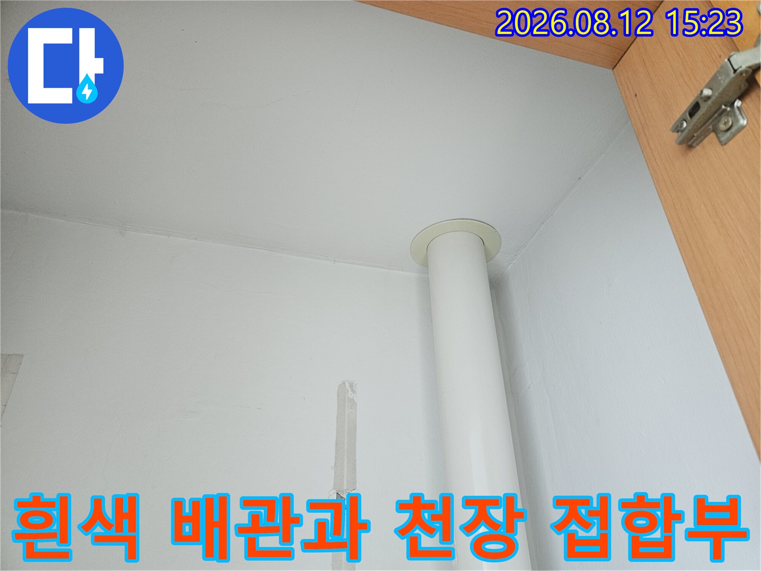 천장 마감재와 수직으로 연결된 흰색 플라스틱 배관-이음새 부분