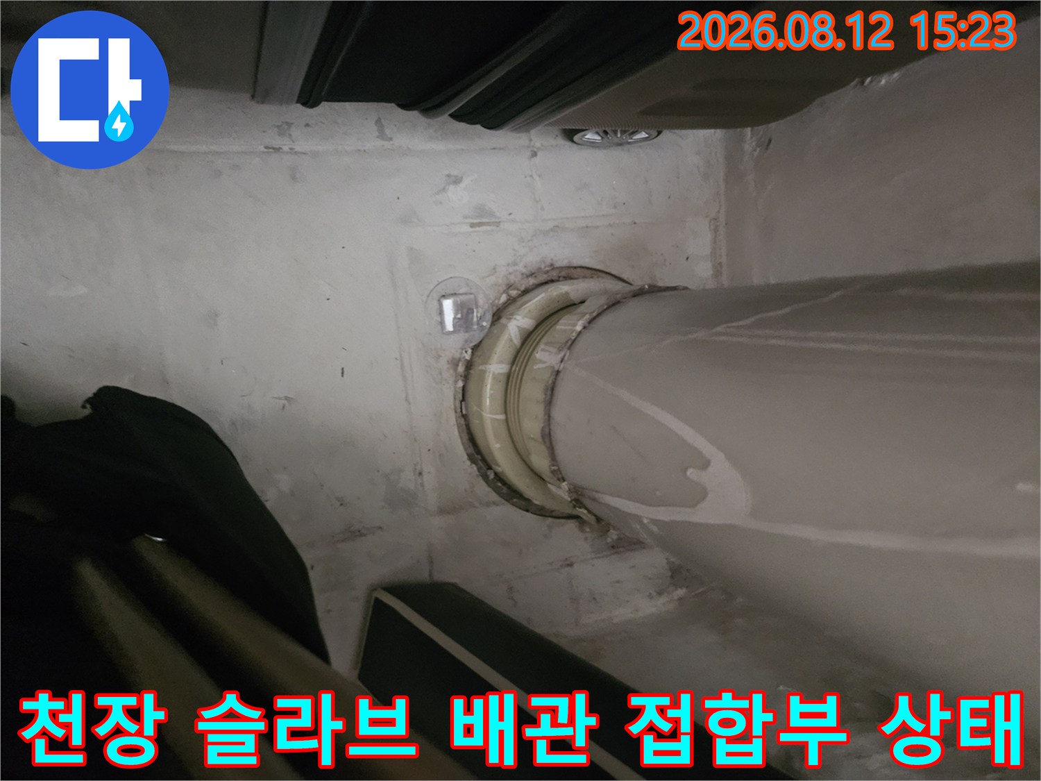 콘크리트 천장에 설치된 회색 PVC 배관 주변의 누수 오염-사진