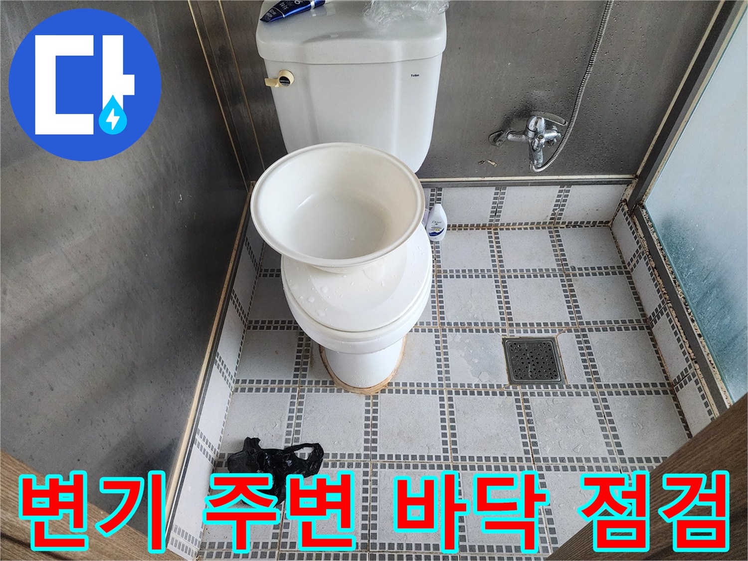 화장실 변기 주변의 타일 상태와 배수구 모습입니다.