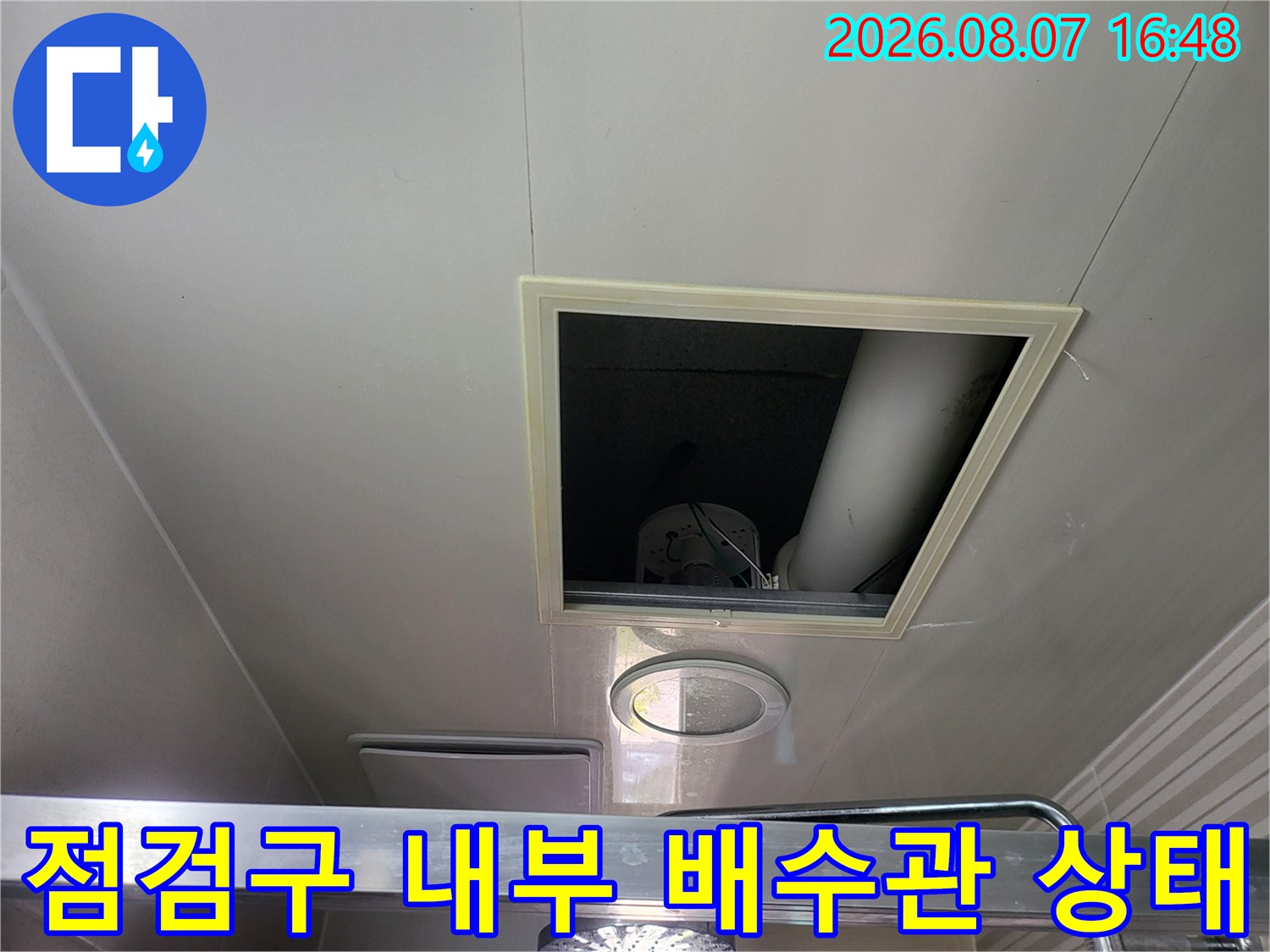 천장 점검구 안쪽의 하얀색 배관과 천장 구조물 촬영