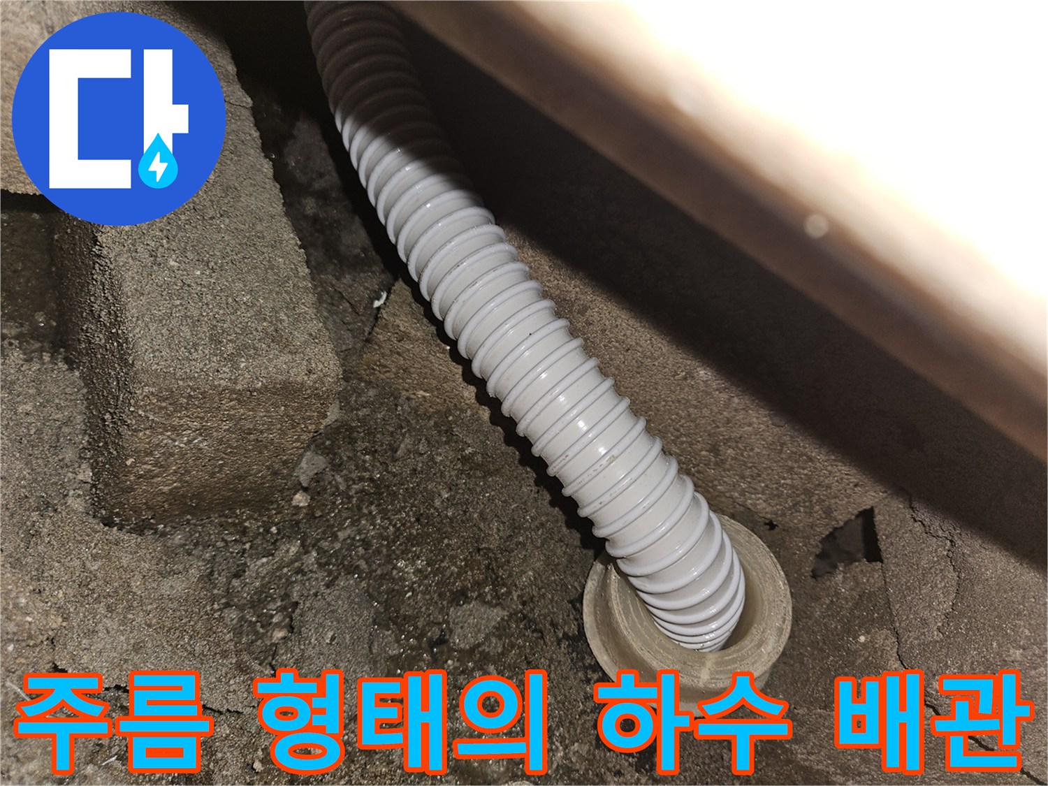 콘크리트 구멍을 통과하는 유연한 흰색 배수 호스
