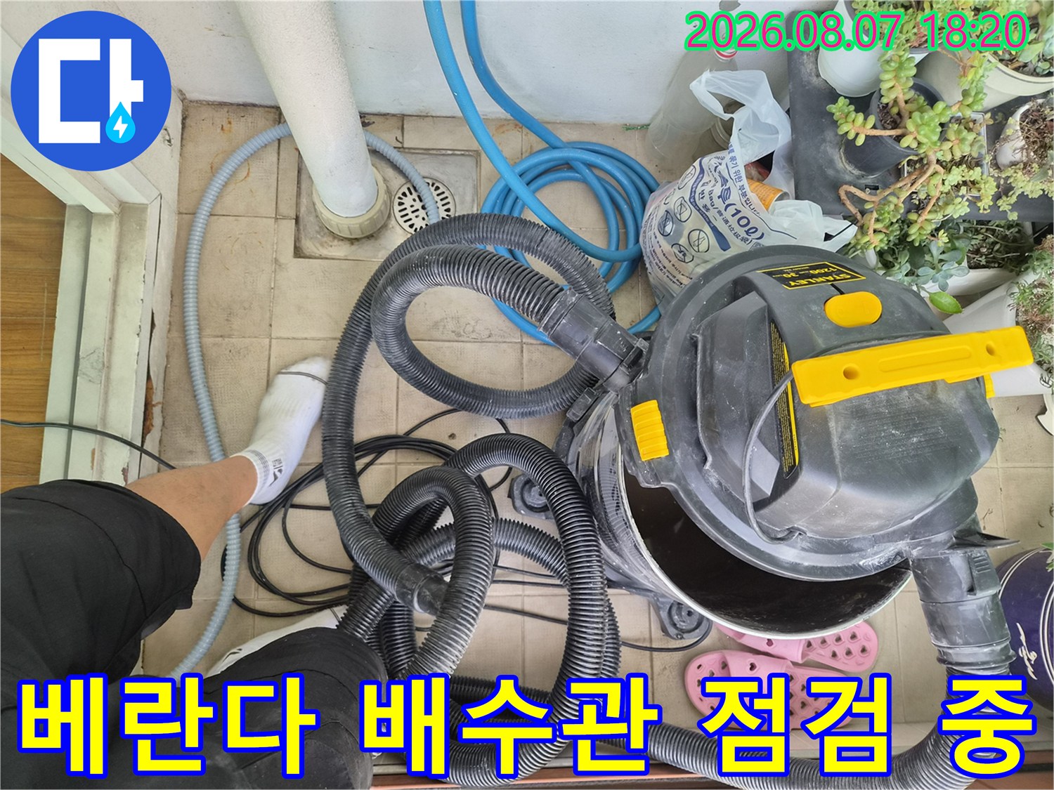 타일 바닥의 배수구와 연결된 각종 호스 및 장비가 놓여 있습니다.
