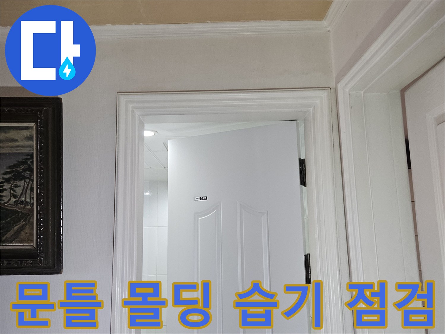 화장실 문 상단 몰딩과 벽면의 연결 부위를 근접 촬영한 사진입니다.