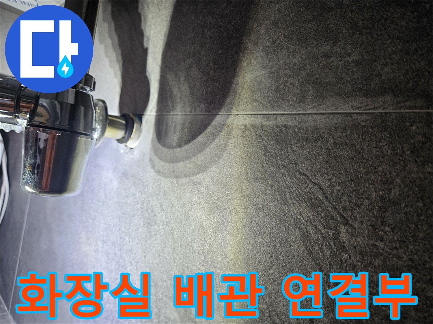 어두운 타일벽면에 설치된 크롬 도금 수도 배관 부위