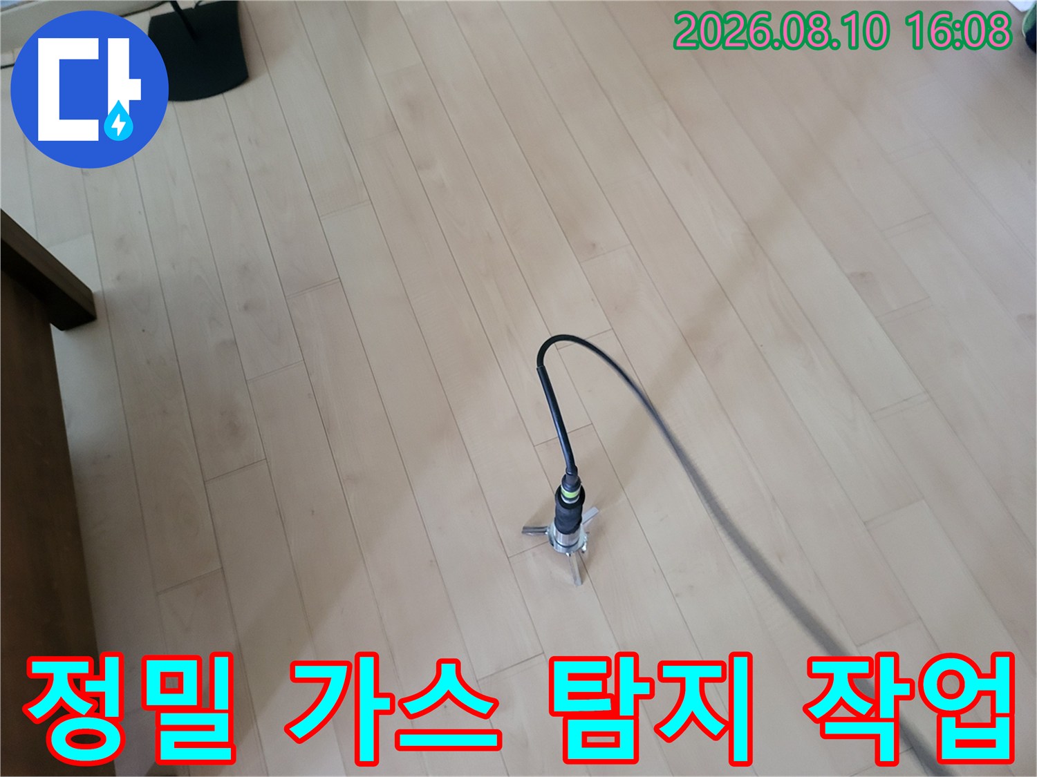 거실 나무 바닥 위에 놓인 배관 누수용 가스 탐지 센서와 연결 호스