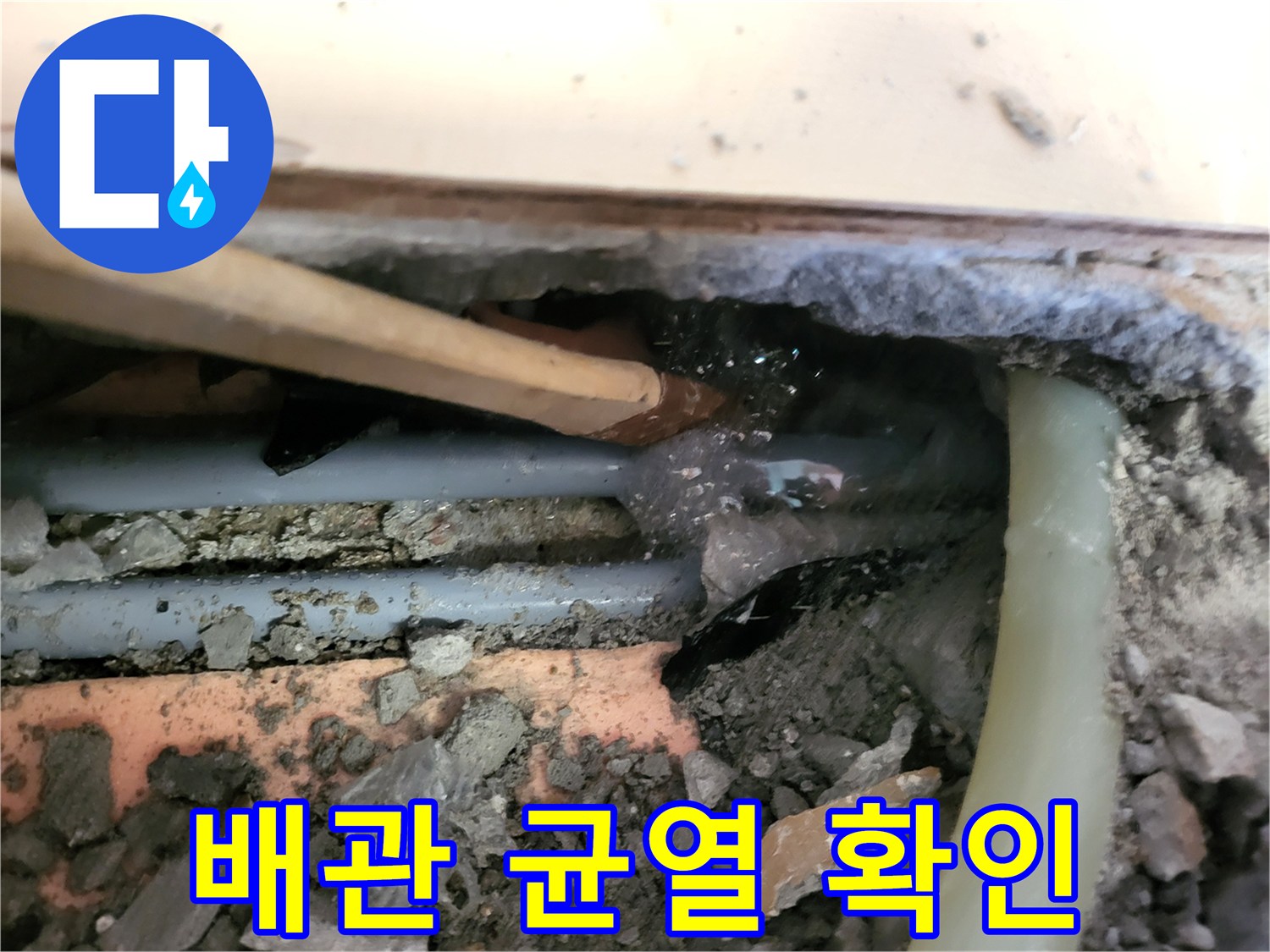 젖은 흙과 함께 드러난 배관의 파손 부위