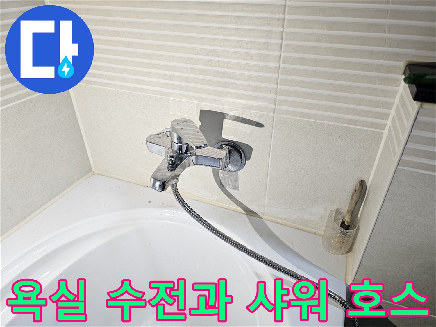 욕조 벽면에 설치된 크롬 도금 수전과 샤워기 호스 이미지