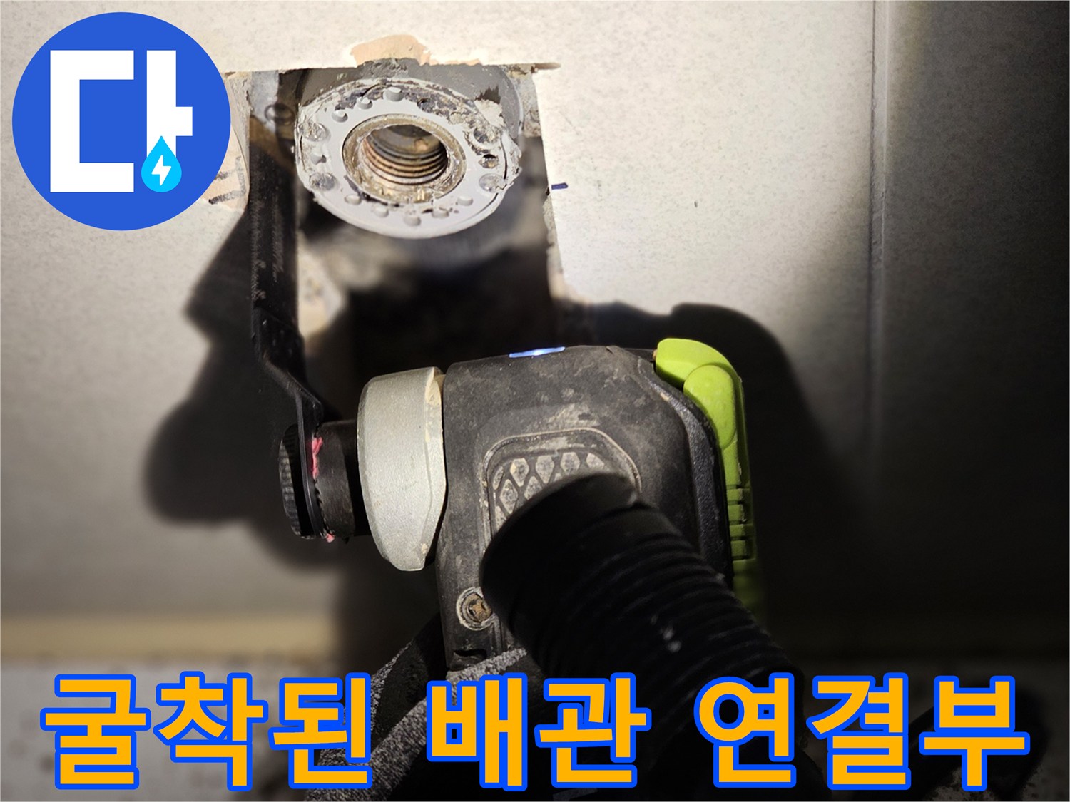 타일이 제거된 공간-드러난 금속 배관의 연결 상태를 보여줍니다.