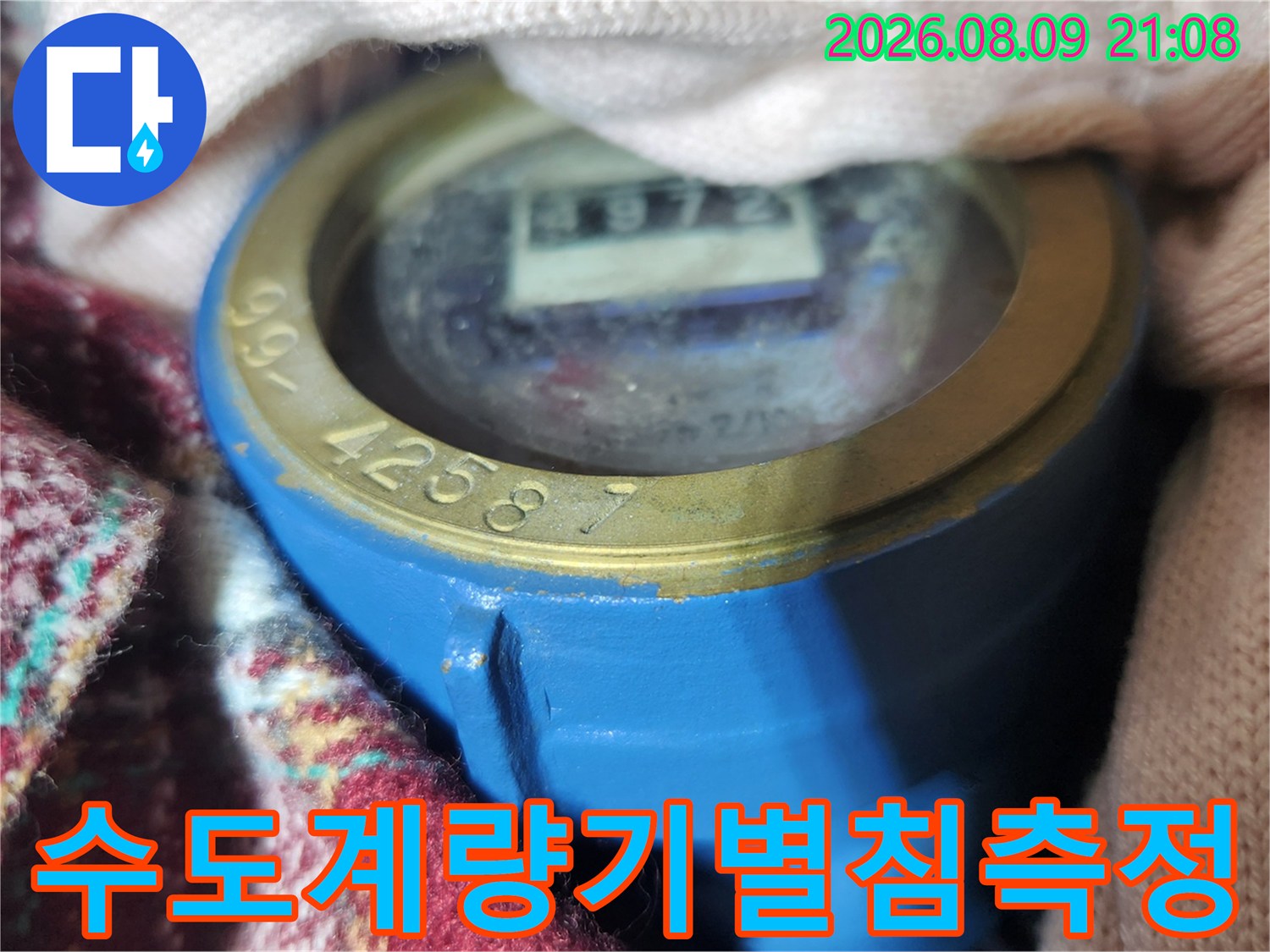 금속 테두리와 파란색 몸체의 수도 계량기 지시창 확대 사진