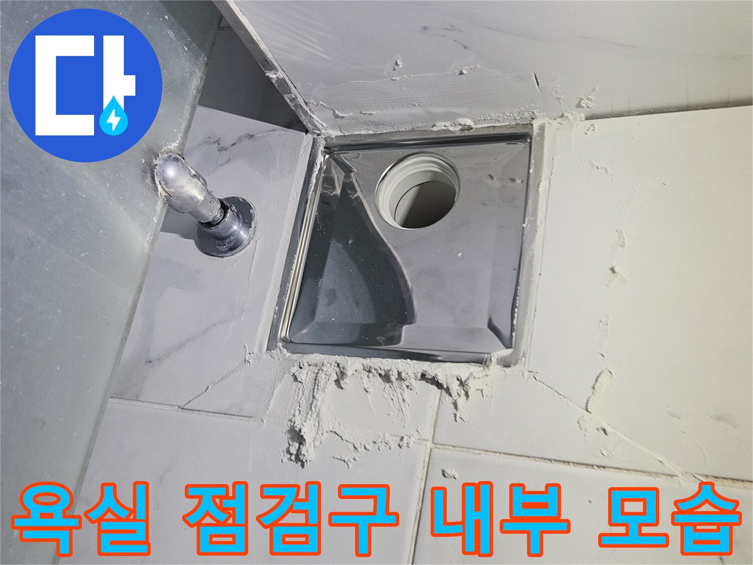 화장실-타일-벽면에-매립된-배관-점검구를-열어-내부를-촬영한-사진
