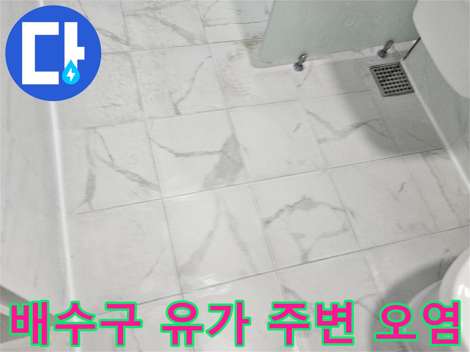 흰색-대리석무늬 타일과 금속제 배수구가 설치된 화장실 바닥면