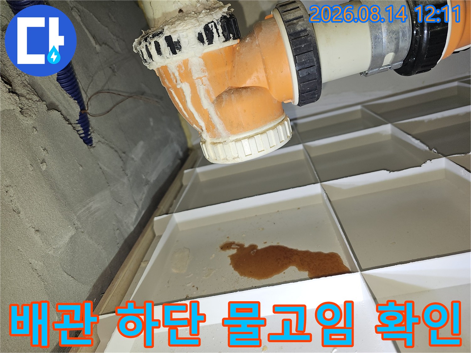 배관 연결 부위 아래 천장재에 고여 있는 갈색 누수물