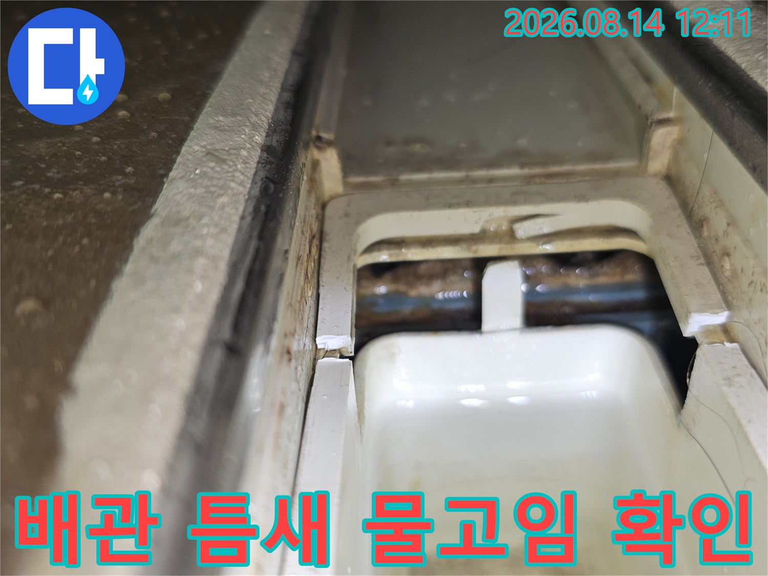 배관과 구조물 사이의 틈새에서 발생하는 누수 흔적을 세밀하게 관찰하고 있습니다.