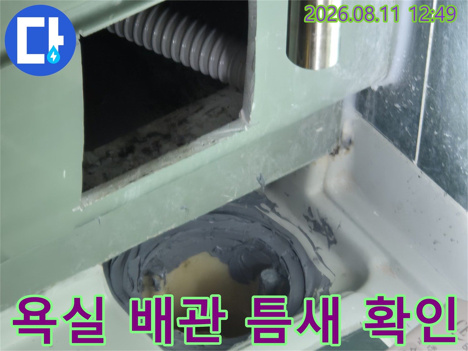 욕실 내부 배관의 연결 부위와 마감재 상태를 근접 촬영한 사진입니다.