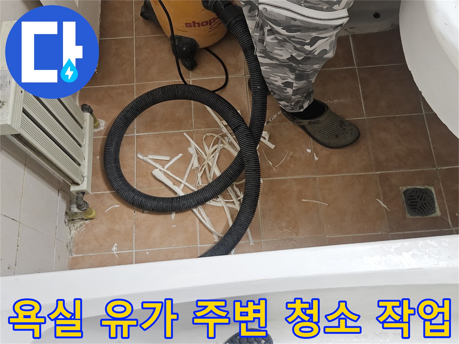 일산 현장-배수구 주변의 타일 조각과 진공 장비