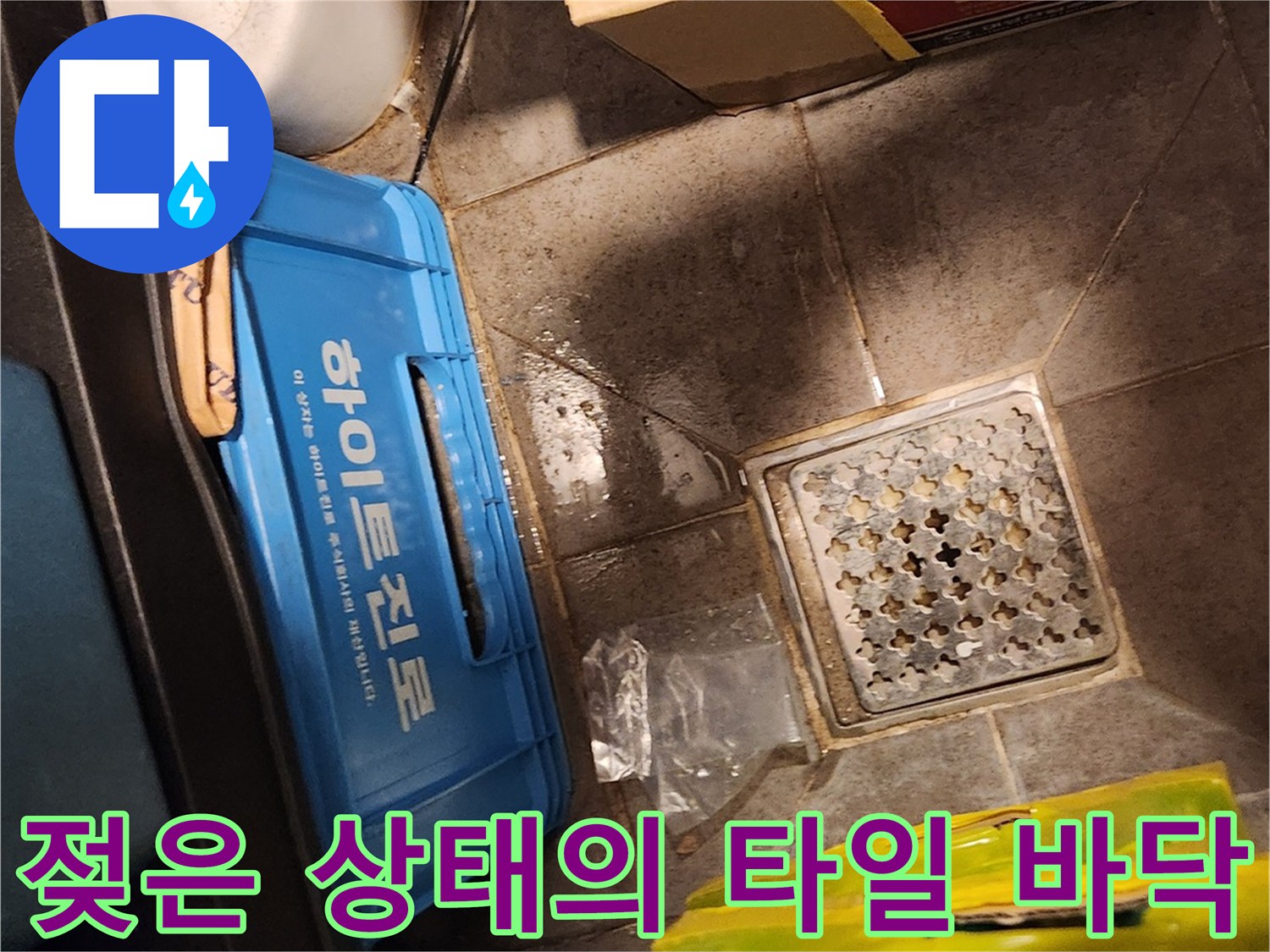 창고 내부의 물기가 남아 있는 배수구와 주변 타일