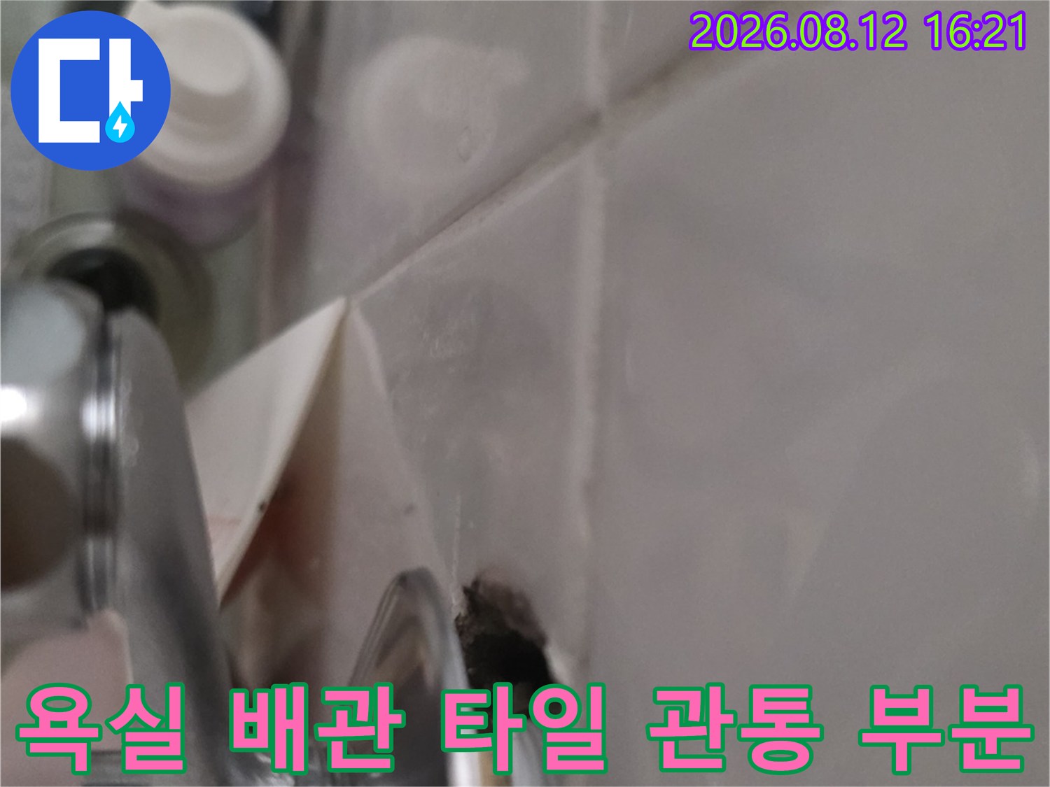 금속 소재의 세면대 배관이 벽면 타일을 통과해 연결된 지점-누수 발생처
