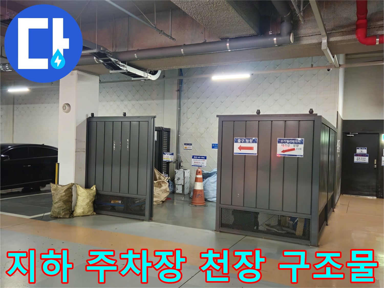 상가 지하 주차장 천장의 은색 대형 배관과 전기 설비 라인