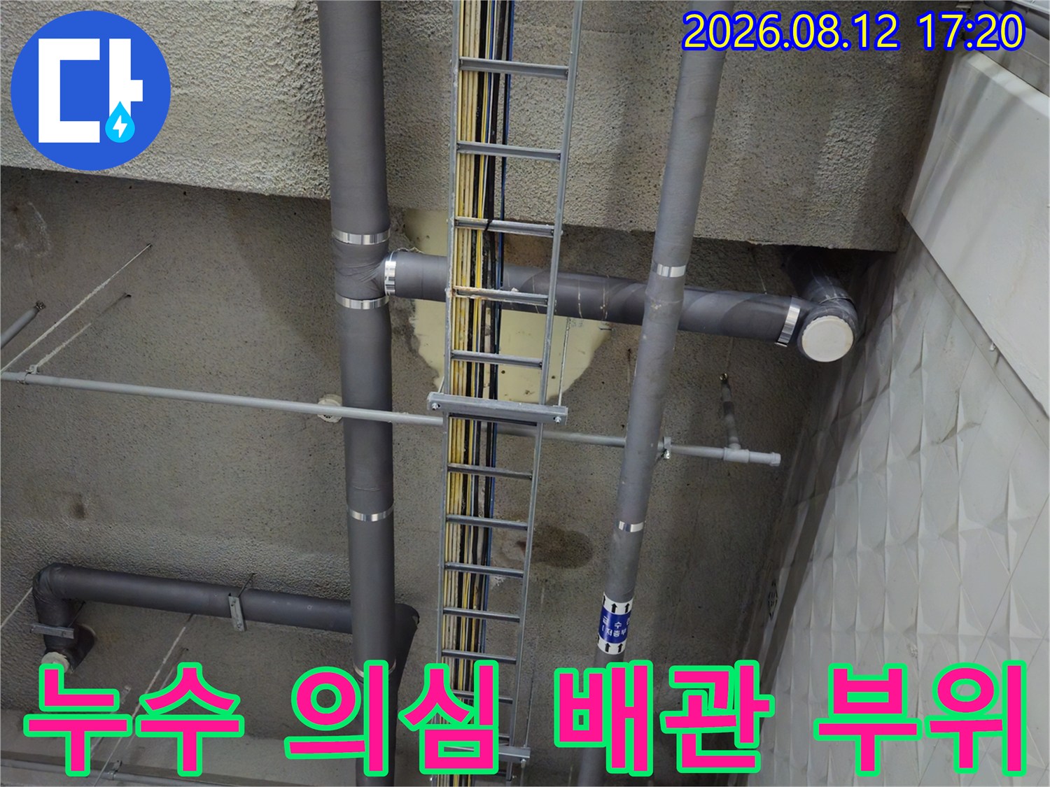지하 주차장 천장 배수관과 케이블 트레이의 근접 모습