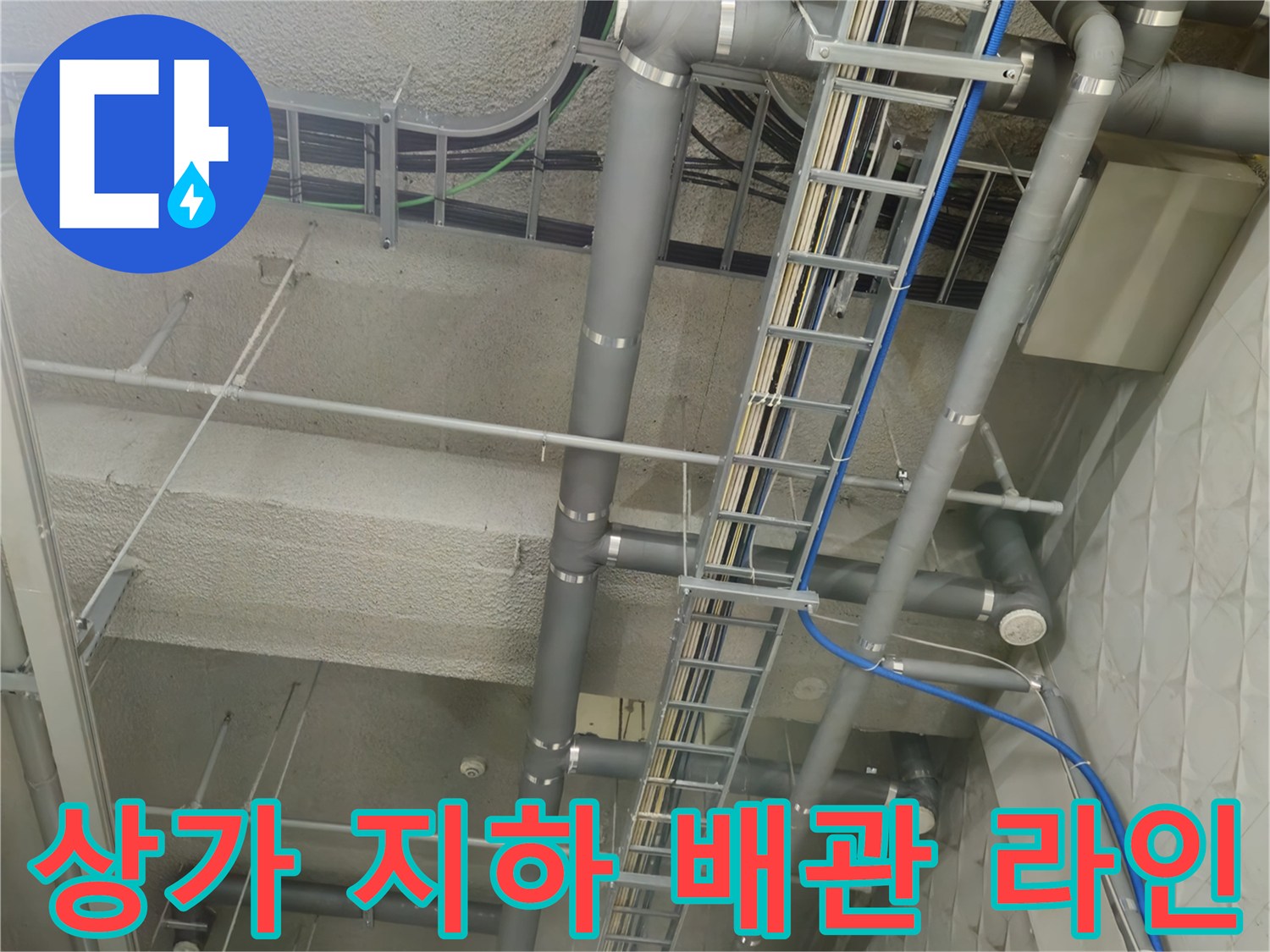 회색 PVC 배수관과 전선이 지나가는 상가 지하 천장
