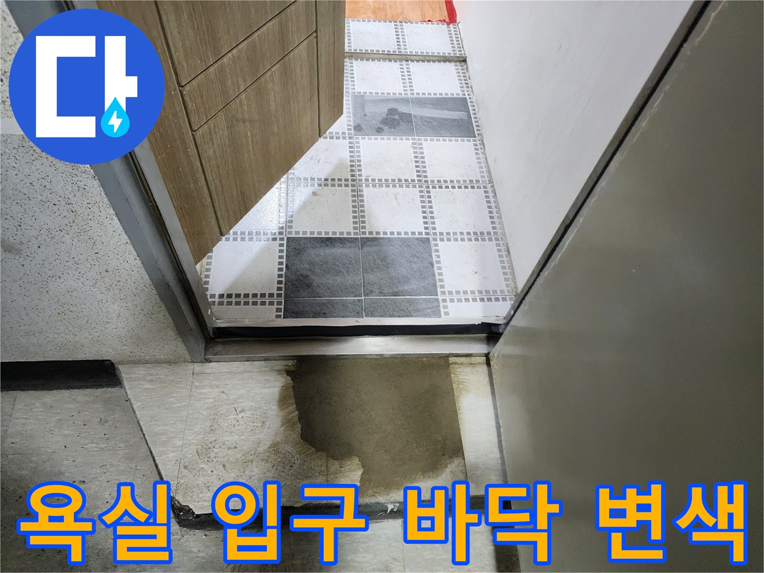 습기로 인해 짙게 얼룩진 화장실 문 앞 바닥 마감재 모습