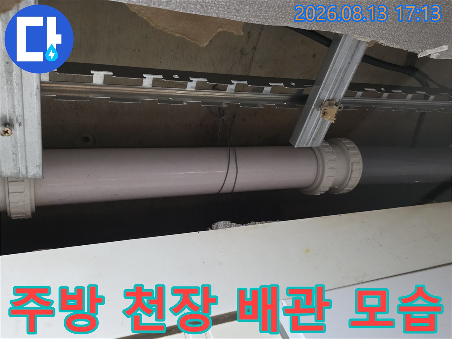 천장 내부 금속 지지대와 연결된 하수 배천의 근접 촬영입니다.