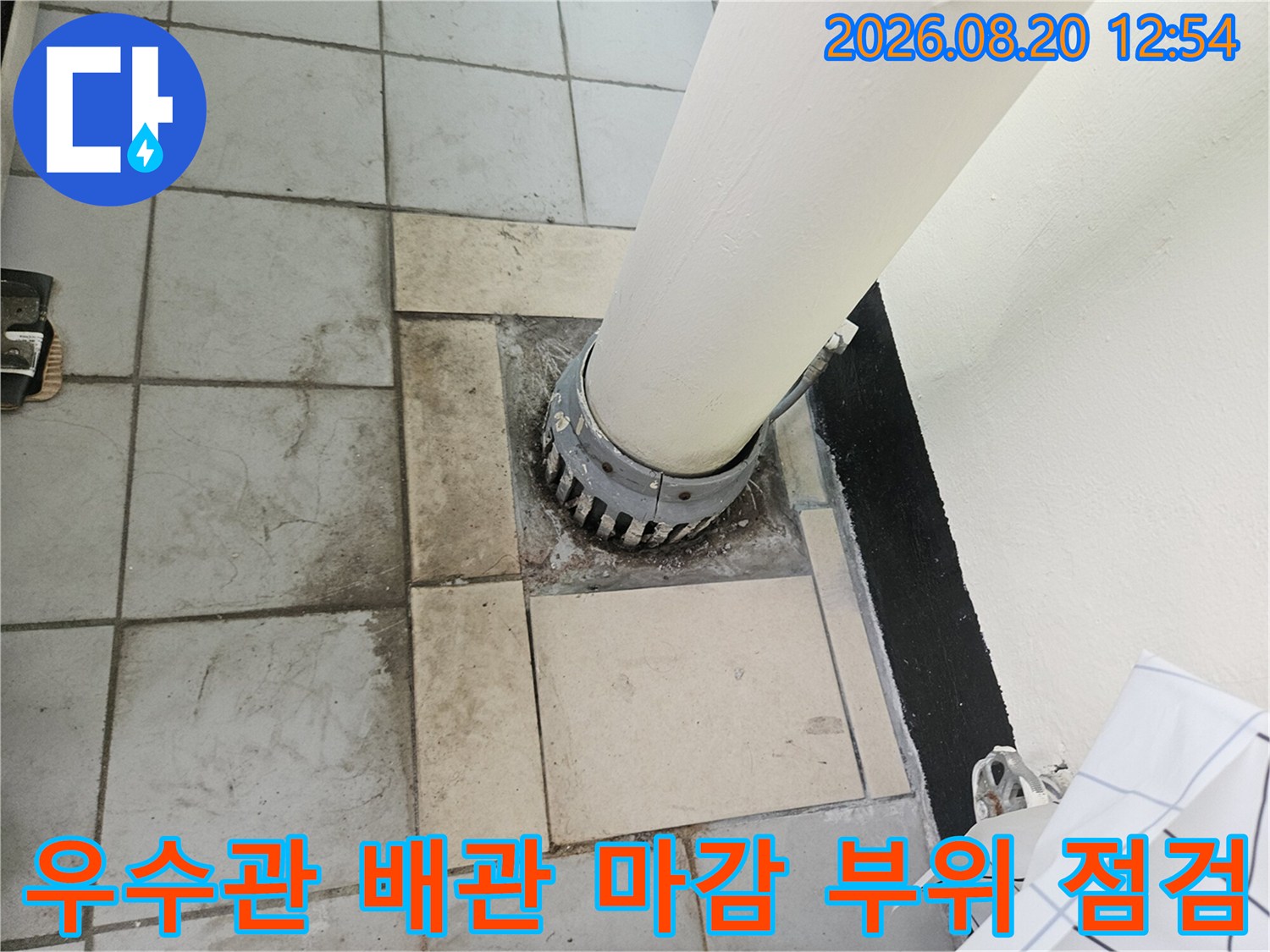 우수관 배관과 타일 접합부의 누수 흔적을 클로즈업한 사진입니다.