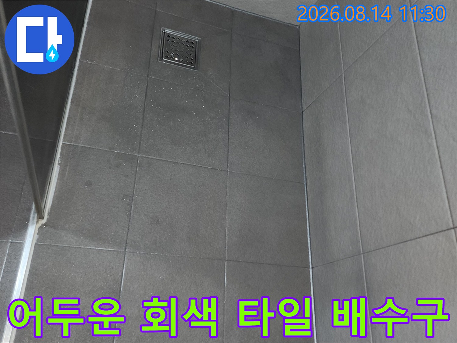 회색 욕실 타일과 금속 소재의 배수구 유가 근접샷