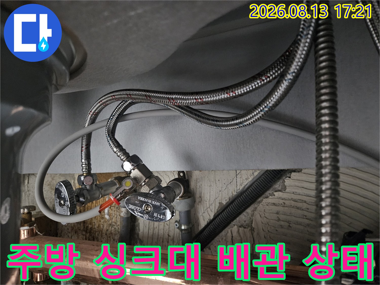싱크대 하단에 연결된 은색 호스와 밸브의 근접 촬영 사진입니다.