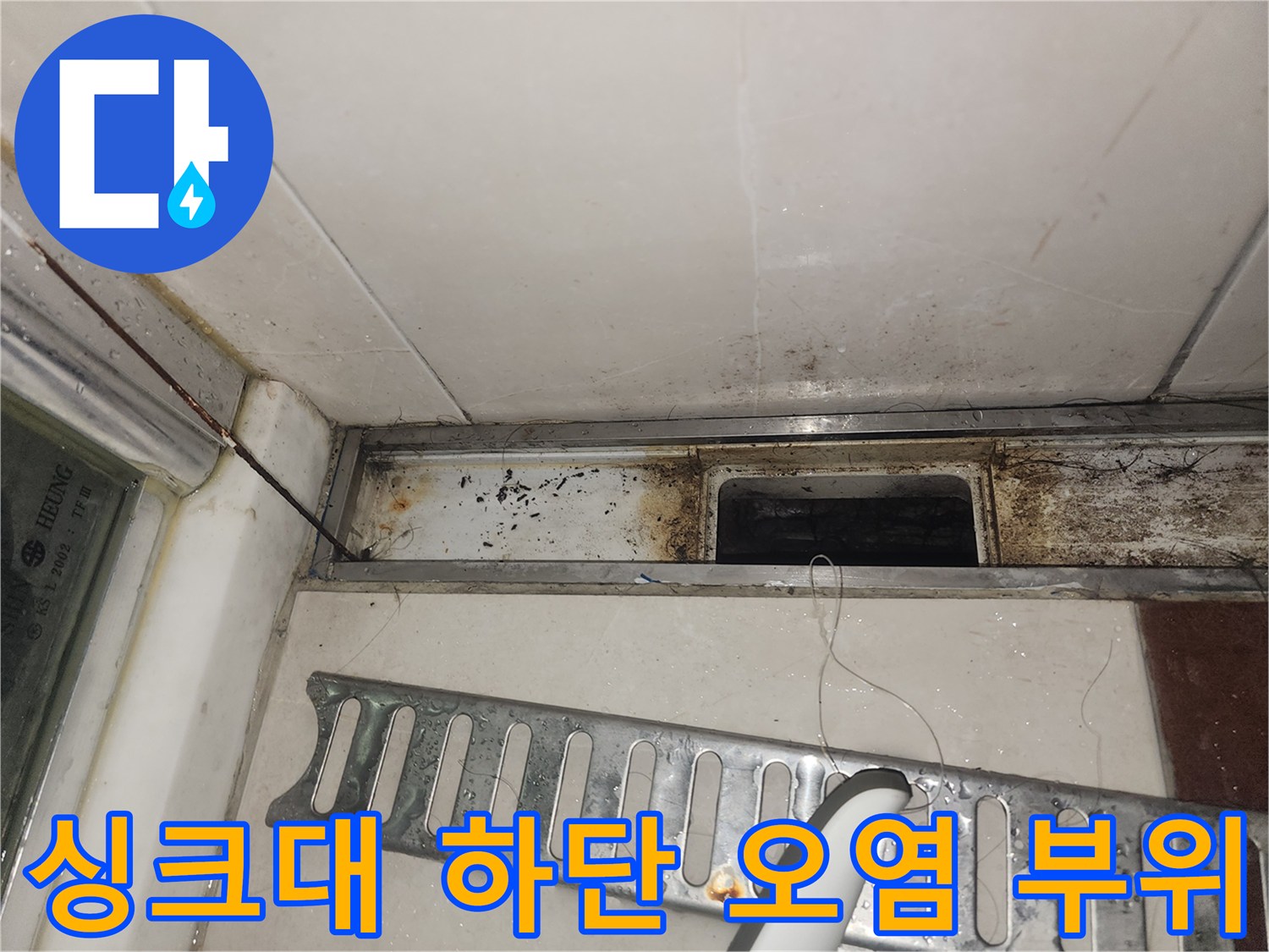 배관 연결부 주변의 젖은 마감재와 검은 얼룩을 촬영한 사진