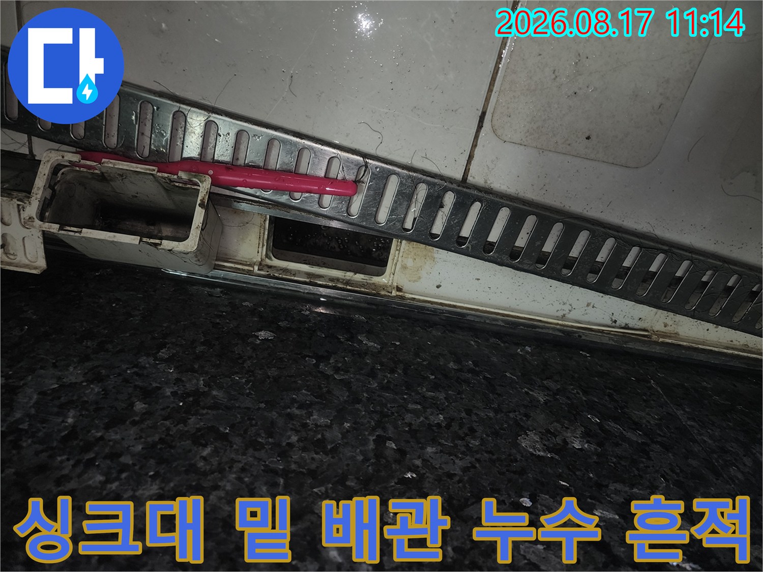 싱크대 하단 타일 틈새에 물기가 스며들어 오염된 현장 사진입니다.
